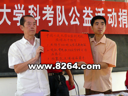 乌镇中学校长张树藩从人大科考队指导老师刘超手中接过捐赠的物资
